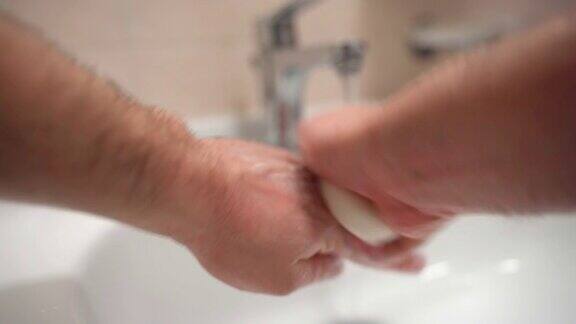 卫生间的日常卫生男士用精致的肥皂小心洗手清洁手指和手掌防止细菌和细菌滋生冠状病毒扩散流行期间的卫生规则