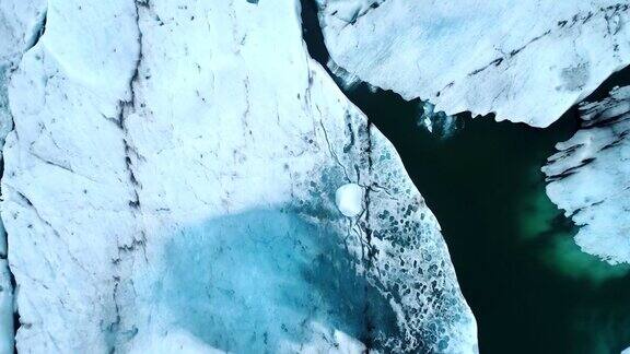 在冰岛南部海岸的Jokulsarlon泻湖上无人机在漂浮的冰山上空飞行