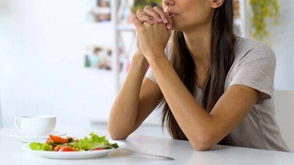 年轻女子吃饭前祷告祈求上帝保佑食物信仰基督教