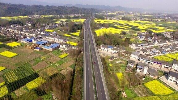 鸟瞰图的中国乡村景观在春天油菜种子盛开和村庄在高速公路