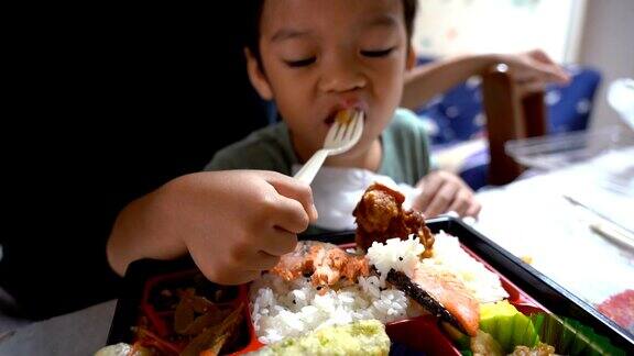 亚洲小孩在当地的房子里吃日本食物