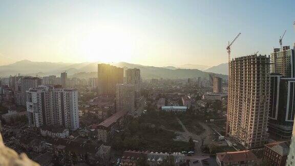 在城市摩天大楼建筑工地的塔吊上的日出间隔拍摄