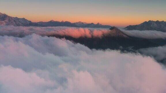 日出时云海在雪山前翻滚显得格外壮观