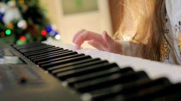 妈妈帮助孩子弹钢琴近距离的手指敲击钢琴键