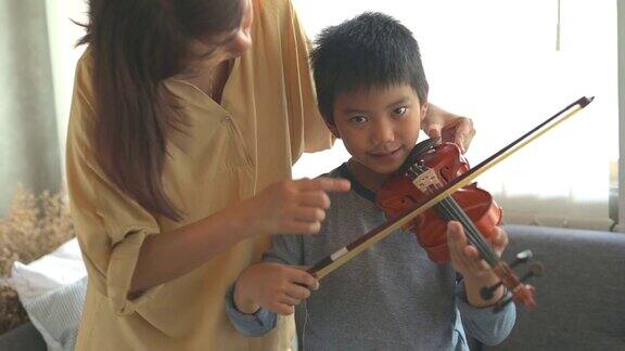 快乐小男孩在家里学习拉小提琴