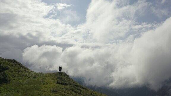 这四个人站在一座山上有美丽的云景