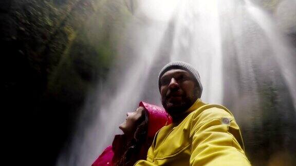 年轻快乐的旅行情侣在gopro相机上自拍冰岛Gljufrabui瀑布附近的一男一女