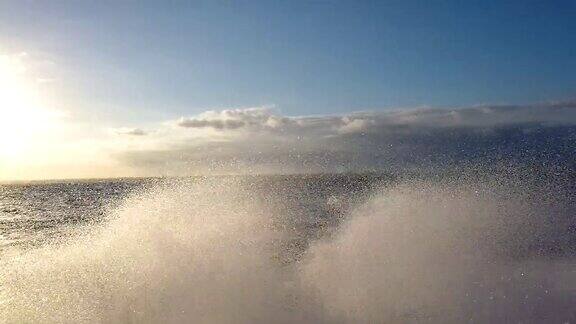 一艘摩托艇快速地游入大海产生巨大的水花汽艇喷出的水花