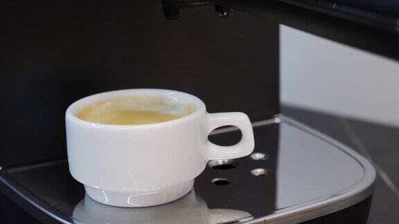 男人从专业的咖啡机中拿出准备好的咖啡咖啡机准备浓咖啡咖啡机煮好咖啡了