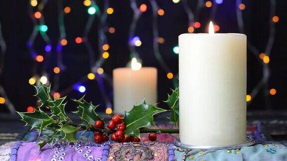 圣诞蜡烛和冬青树与闪烁的仙女灯背景