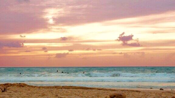 一群冲浪者在日落时在以色列帕尔马希姆海滩的地中海上冲浪