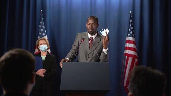 非裔美国政治家在辩论会上摘下防护面具开始演讲