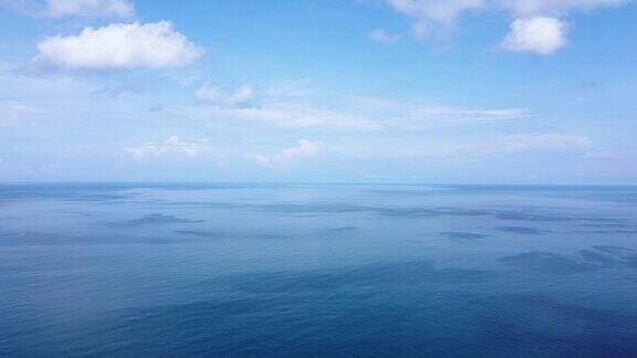 无人机飞行在平静和宁静的蓝绿色海水上方的鸟瞰图平滑的波光粼粼的泰国普吉岛表面