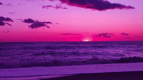 蔚为壮观的粉红紫色日落在海洋上波浪打破海滩令人惊叹的日落景象日落天空自然背景阳光阳光梦幻的天空