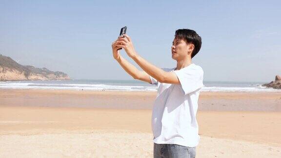 一个人在海边用手机旅行