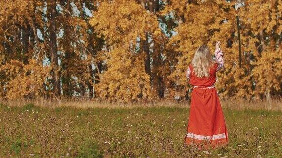 中世纪-妇女在红色民族长连衣裙旋转剑周围自己
