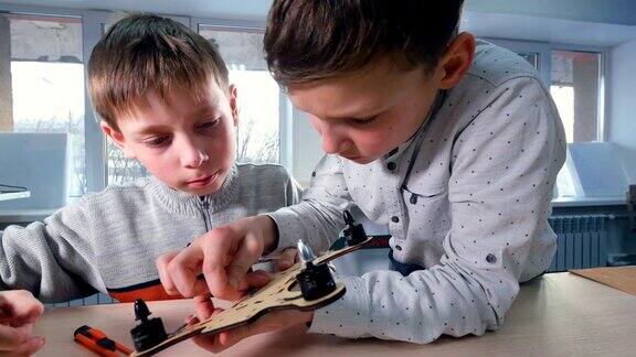 两个男孩正在制作木制无人机模型