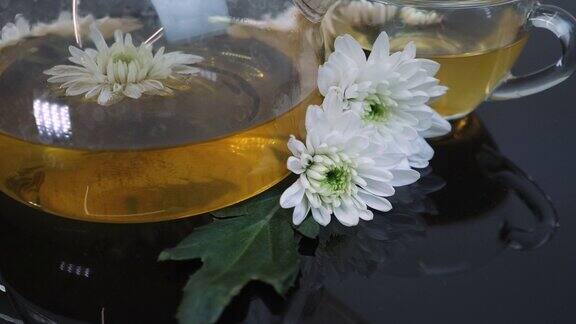 有机菊花茶在玻璃杯Arome喝茶时间健康的草本饮料一杯花茶和茶壶