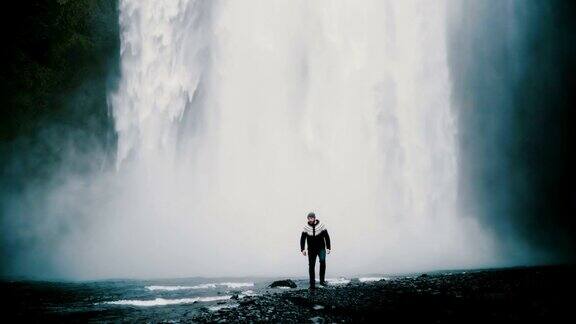 年轻英俊的男子独自走在冰岛强大的Gljufrabui瀑布附近欣赏着风景