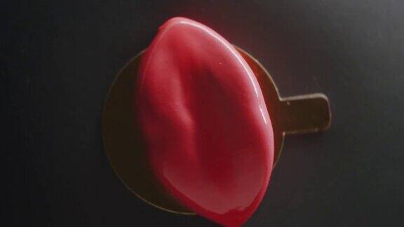 旋转特写美味的甜点在黑色背景上的红唇形状