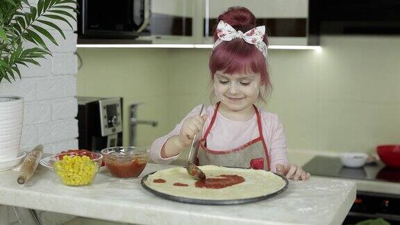 烹饪披萨穿着围裙的小孩在厨房里给面团加番茄酱