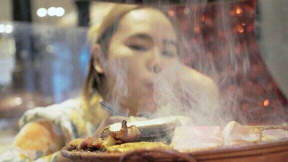 亚洲妇女在餐厅吃韩国烧烤