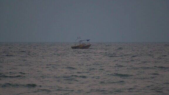 落日时分大海中的小船船在大海的背景在印度果阿的巴嘎海滩上乘坐小船眺望远处的阿拉伯海远处的小船伴着海浪