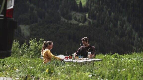 微笑的夫妇在露营时吃早餐