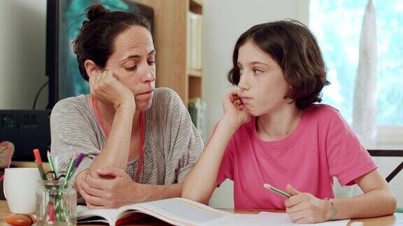 母亲帮助十几岁的女儿做家庭作业
