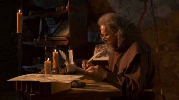中世纪的抄写员在烛光下写作