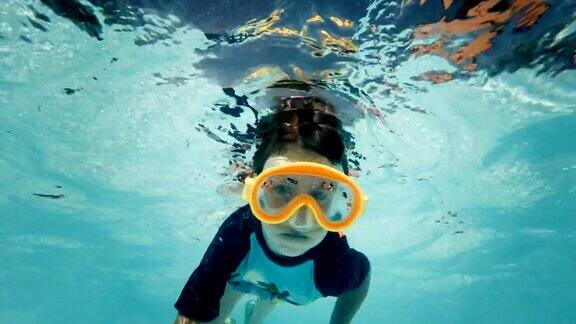 小女孩在游泳池的水下游泳