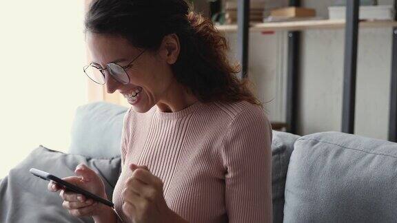 激动的女获胜者在手机短信中收到了好消息