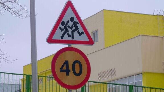 一所学校旁边立着“小心儿童”和“限速40”的路标
