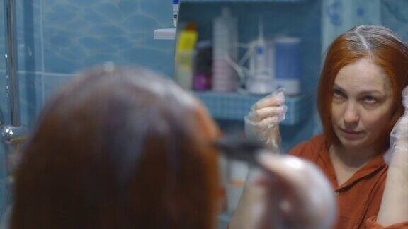 生活方式女人把红头发和灰头发涂在一起在家染发自我照顾