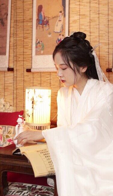 一位身着汉服的中国古代美女正在阅读书籍和竹简