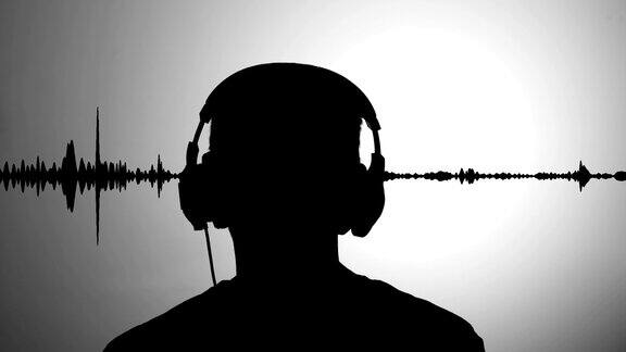 灰色墙壁上的男子黑色剪影戴着耳机听音乐实时波形作为背景