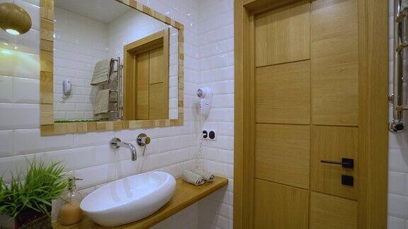 现代化的浴室内部白色的洗脸盆和墙上的镜子酒店服务