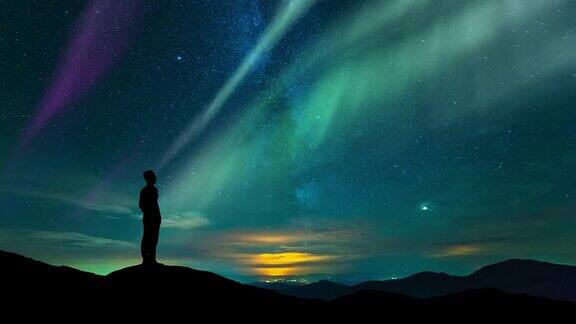 这个人站在星空下拿着北极光时间流逝