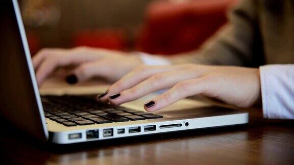 女性的手在咖啡馆里使用笔记本电脑