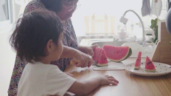 小男孩和爷爷奶奶在厨房里吃西瓜