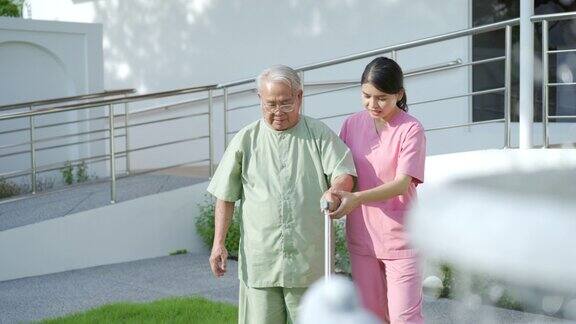 护士带着老人在公园里练习散步