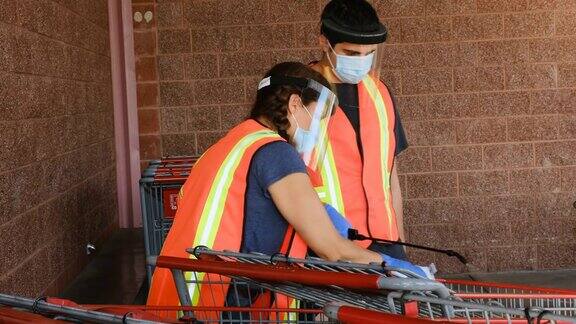 超市员工戴着口罩和乳胶手套对购物车进行消毒防止传染