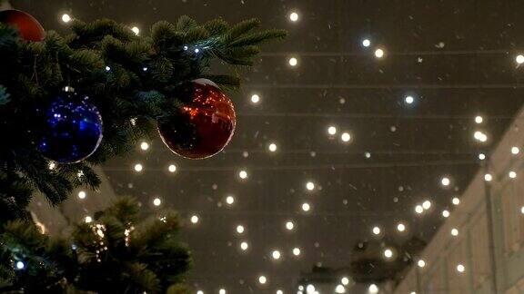 新年球挂在圣诞树上彩色的灯红球街树白雪覆盖