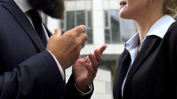男、女同事在户外争吵、打手势、发生冲突