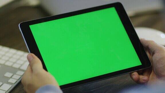 设计师在工作中使用带绿屏的平板电脑