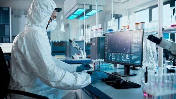 实验室:穿着无菌工作服、面罩和面罩的医学科学家在计算机上开发疫苗、药物和抗生素屏幕显示高科技概念的DNA研究
