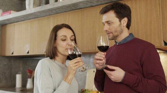 微笑的夫妇在厨房喝红酒
