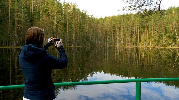 女孩在森林里用手机拍照