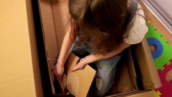 小女孩试图改进她的纸板箱