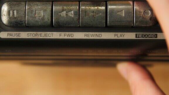 特写的人的手插入音频磁带到复古磁带播放器